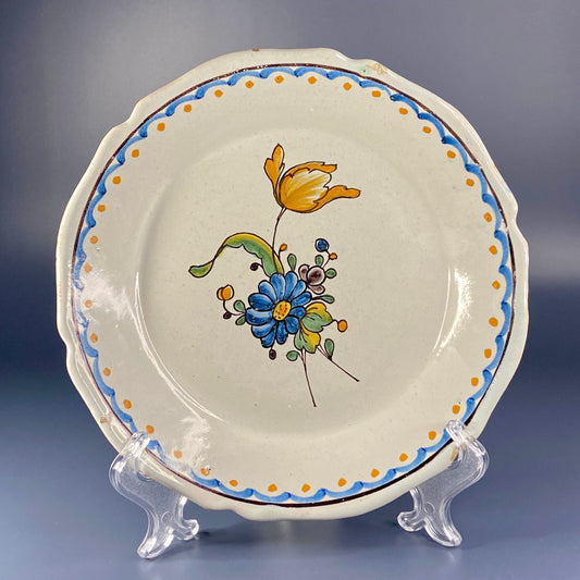A late 18th-century French faience plate from Nevers, decorated with a large blue flower in the centre